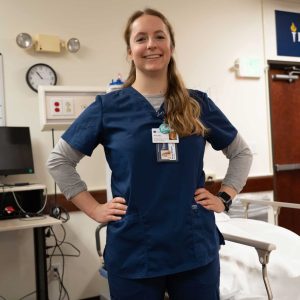 Female nursing student smiles while in simulation lab