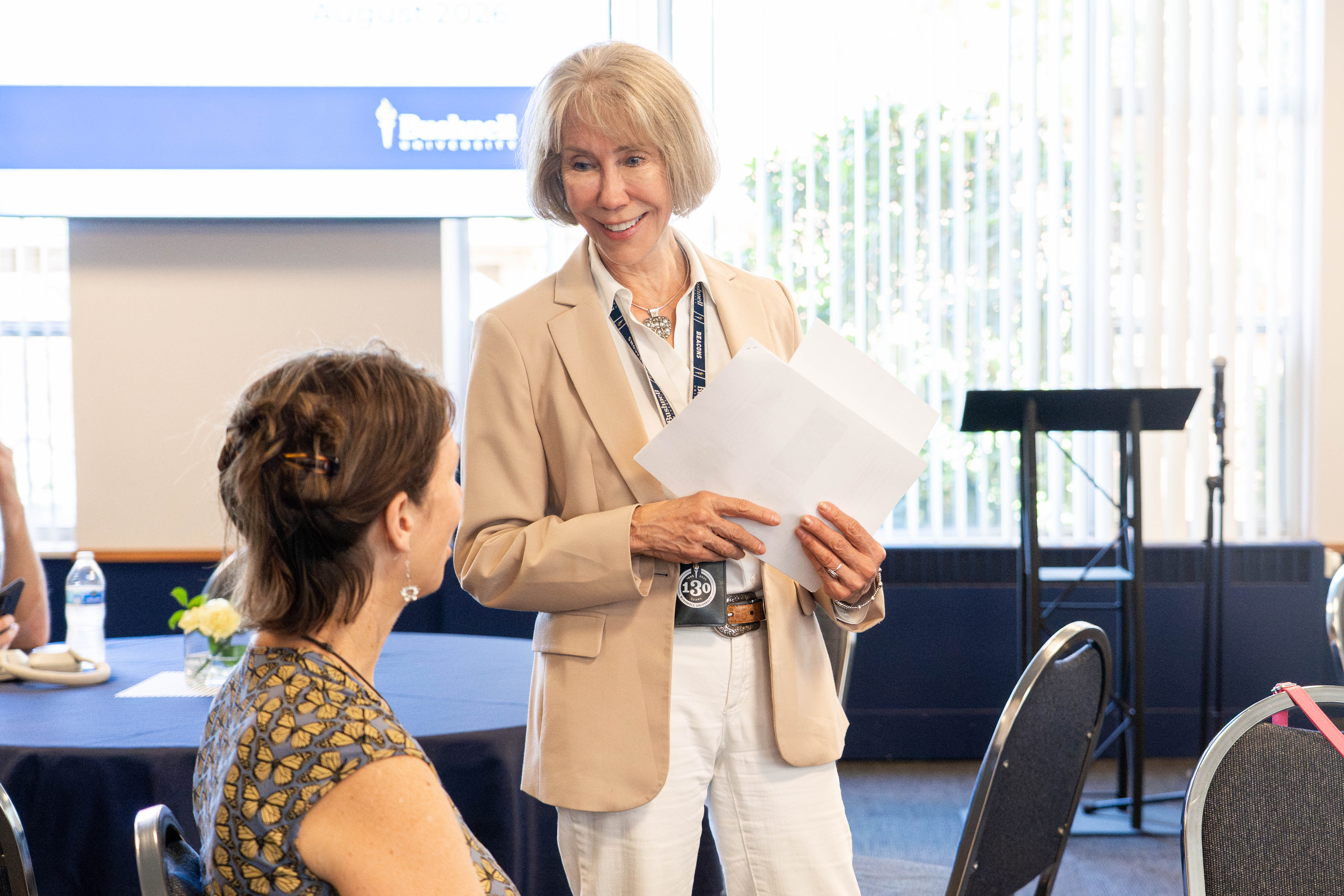Faculty member speaking with student during an event.