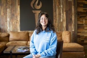 Student smiles in a welcoming campus lounge at Bushnell University.
