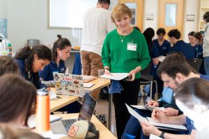 Bushnell University nursing instructor leads a classroom discussion while nursing students collaborate on coursework and case studies.