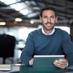 Business professional uses a tablet while working in a modern office.