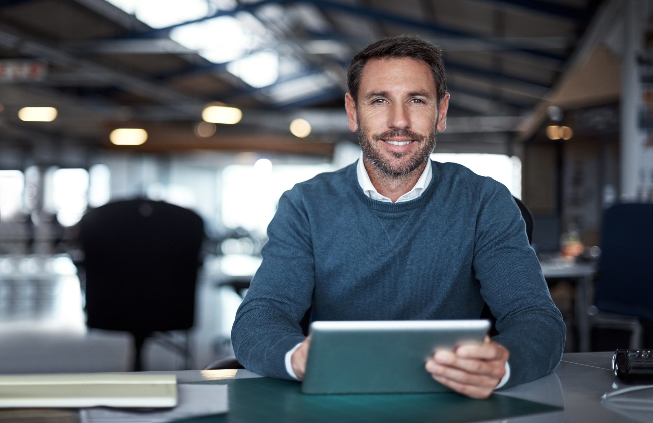 Business professional uses a tablet while working in a modern office.