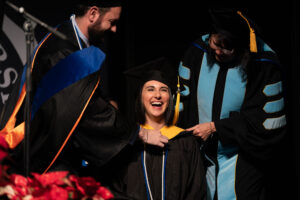 Graduate getting hooded at Bushnell University commencement ceremony
