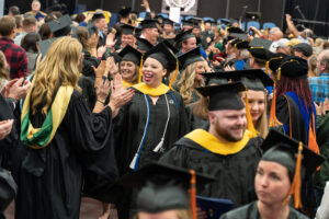 Graduate students receiving high fives from professors after Commencement.
