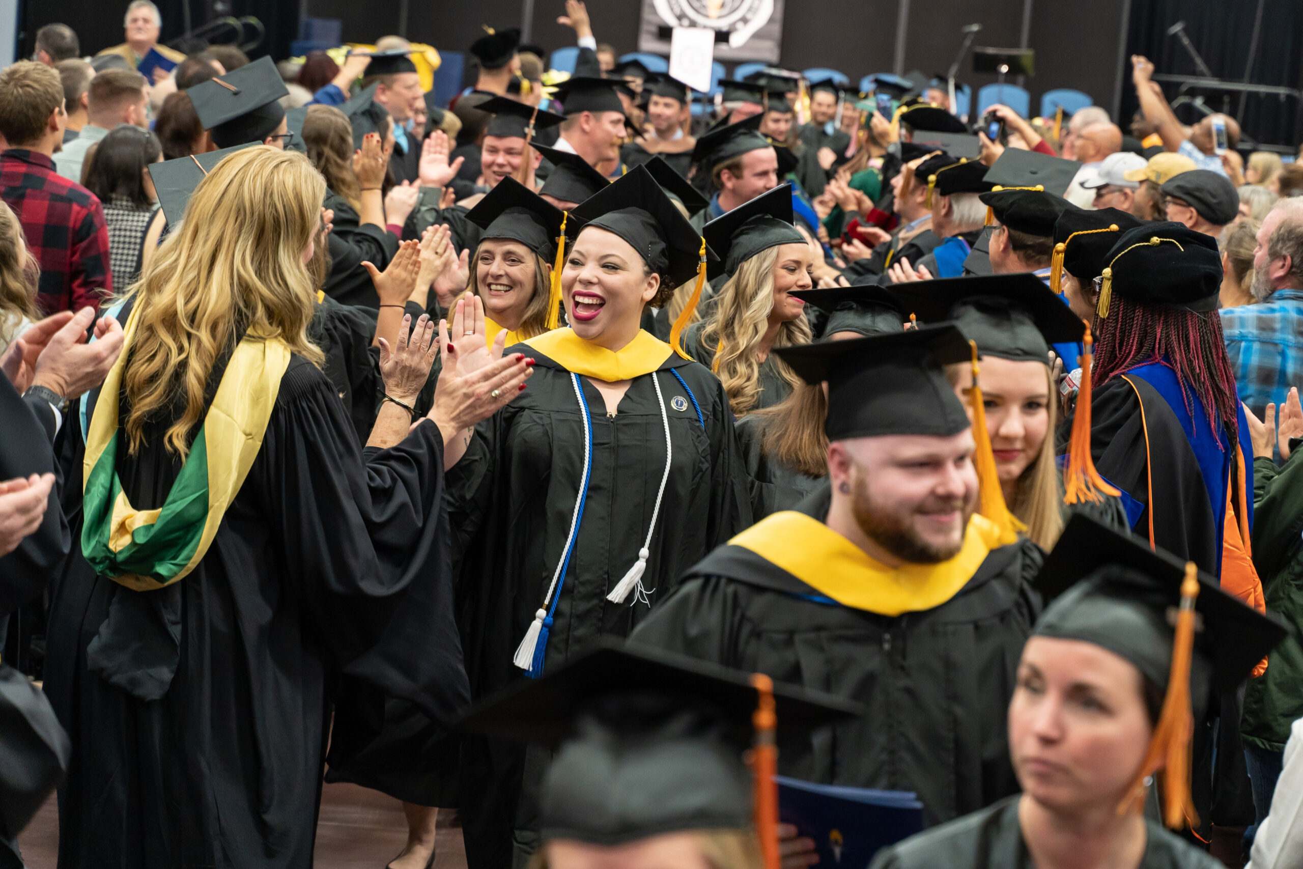 Graduate students receiving high fives from professors after Commencement.