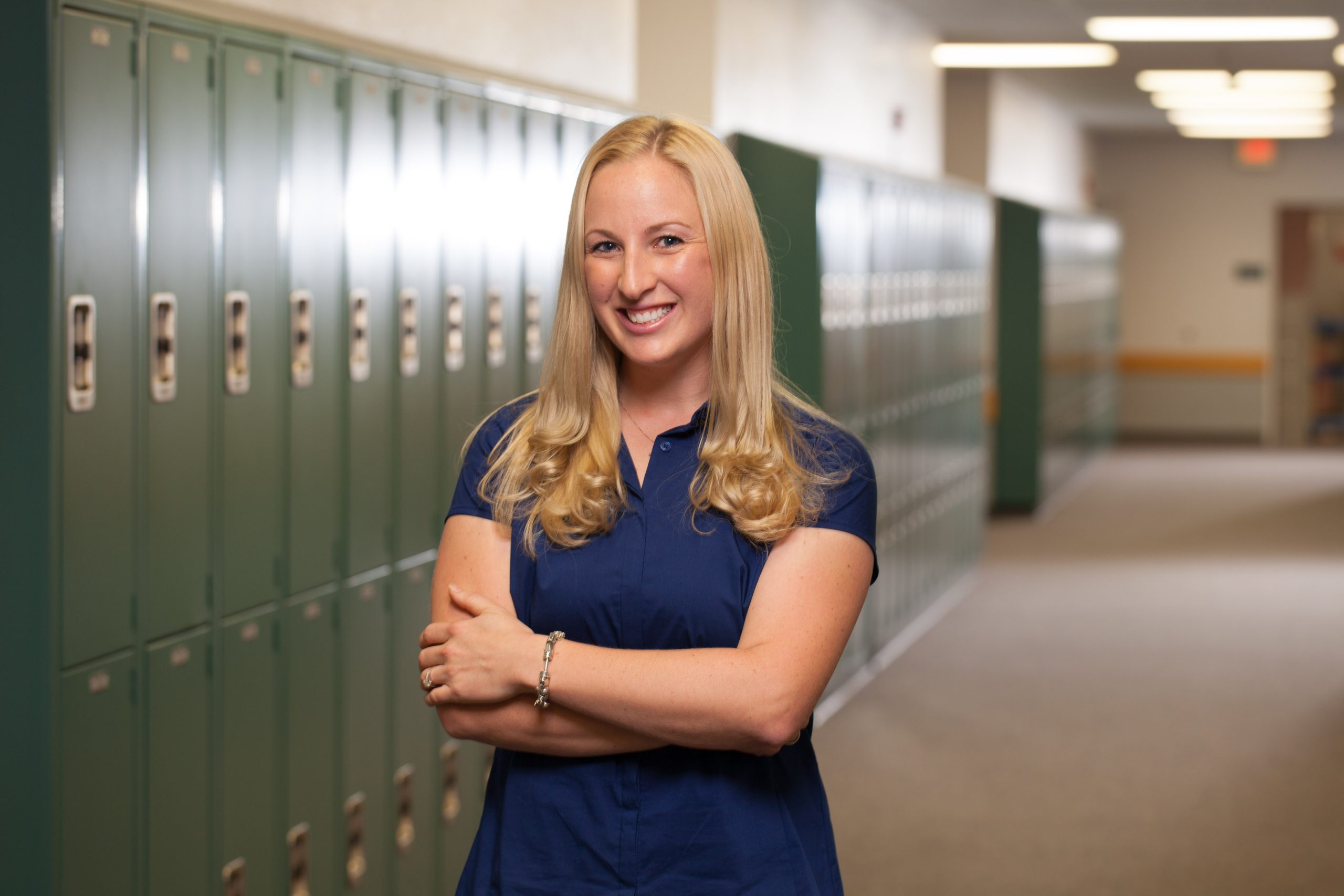 Person standing in a school hallway as part of an education program experience.