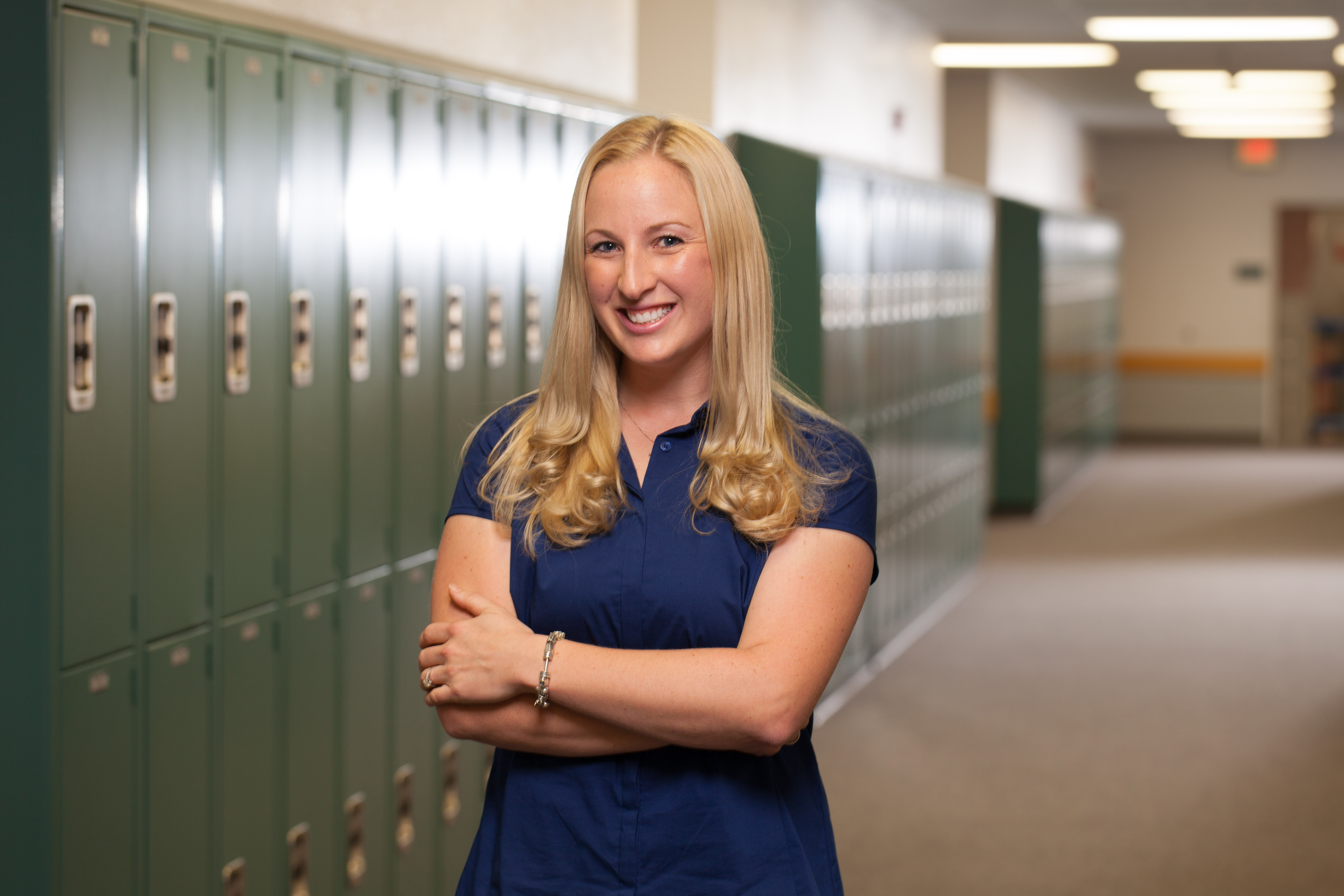 Person standing in a school hallway as part of an education program experience.
