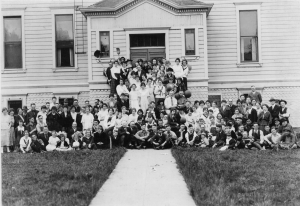 Black and white historical photo of faculty and students in front of campus building