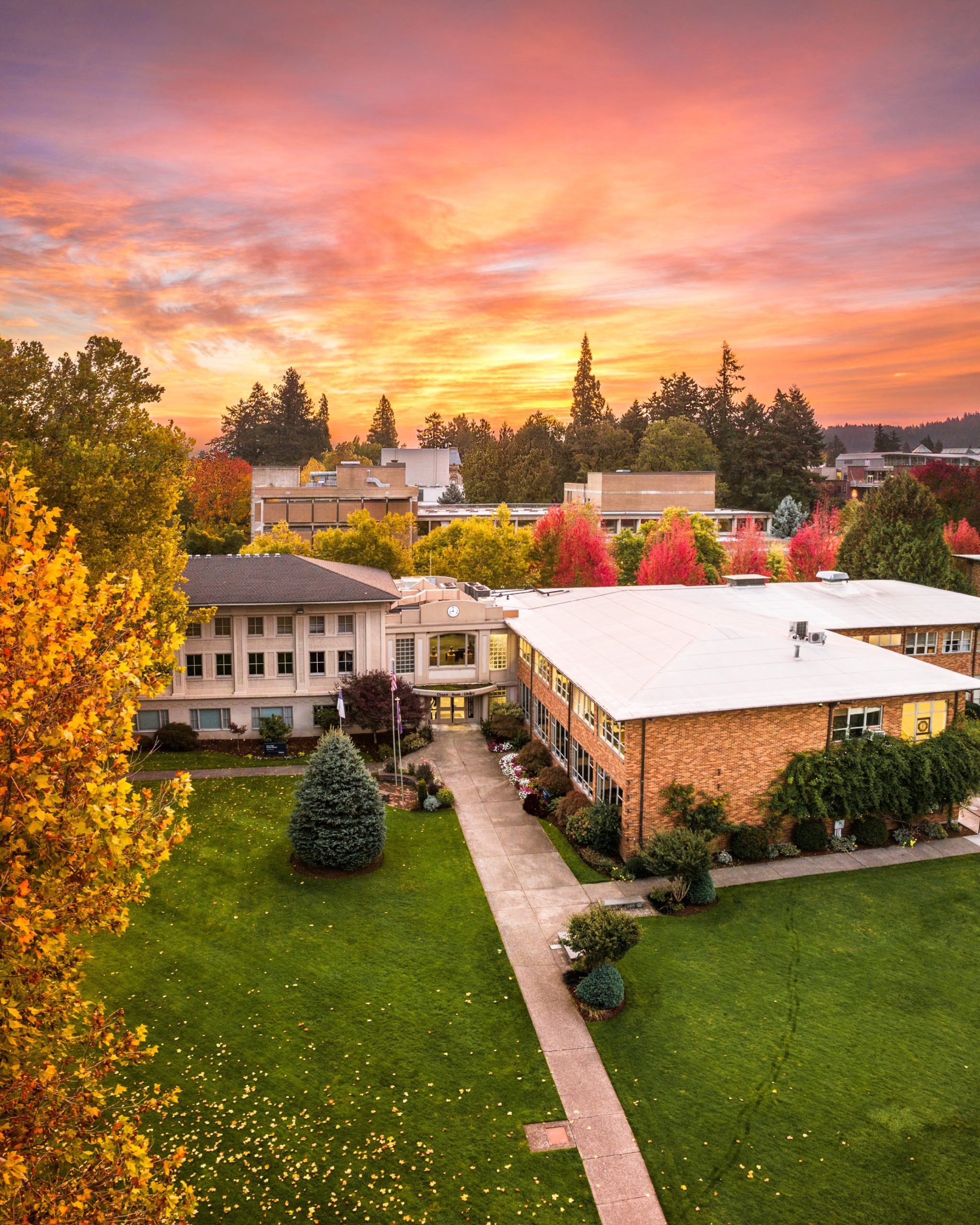 Bushnell University campus buildings with a sunrise in the background