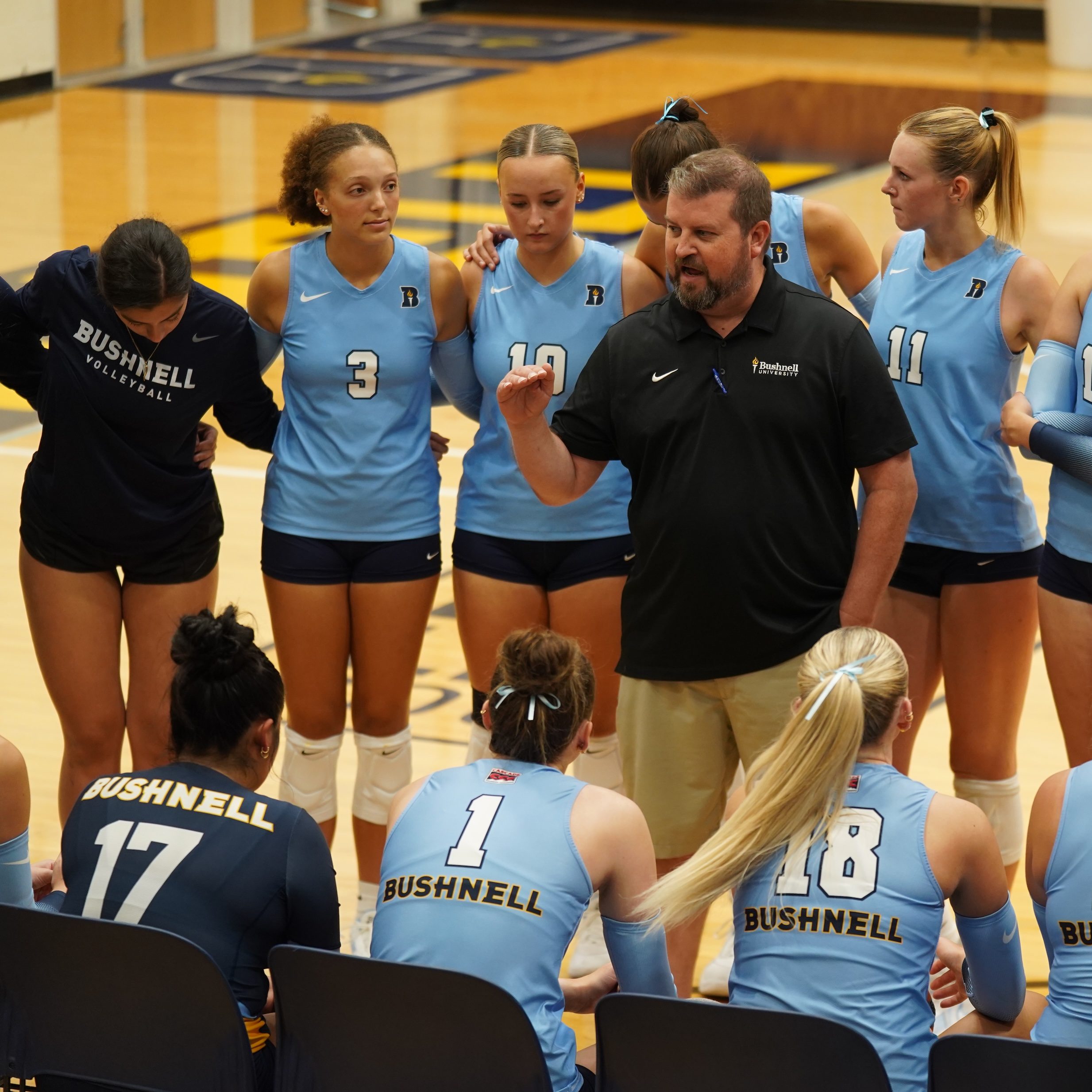 Bushnell University women’s volleyball team gathered around their coach during competition