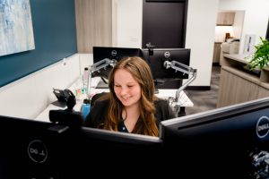 Accounting intern smiling as she works at her computer station