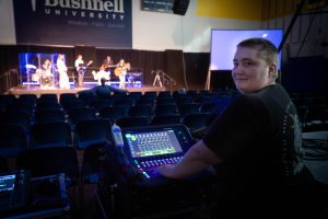 Audio visual production student prepares soundboard for Bushnell chapel