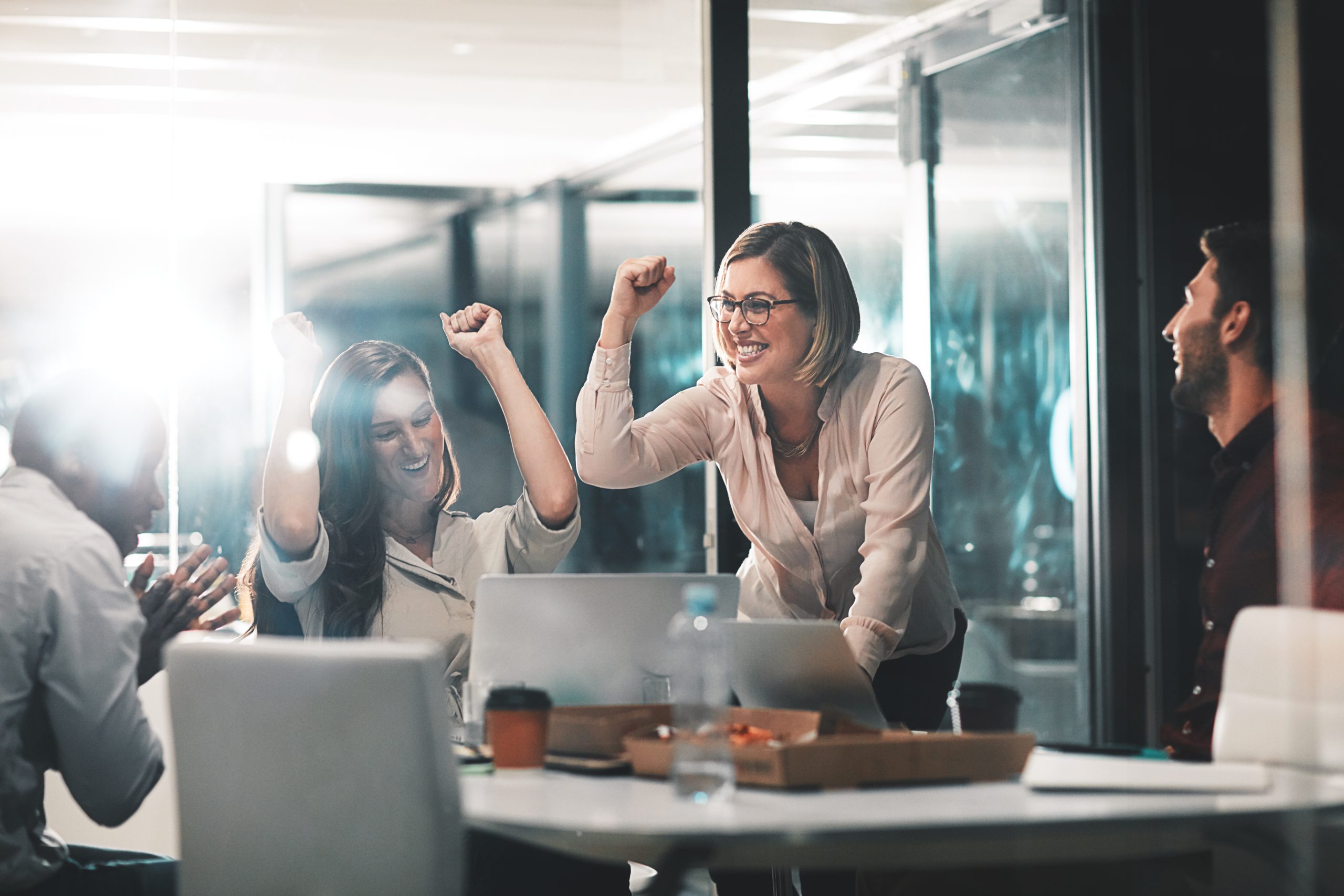 A business leader celebrates success alongside her colleagues in office