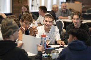 Group of students discuss classwork around a table