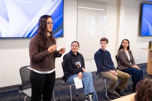Panel of students speak at the front of a classroom