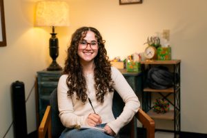 Counseling center intern with a notepad in a counseling room