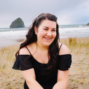 Photo of a female student on a sandy beach with long brown hair
