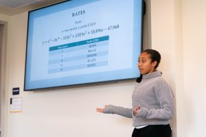 Mathematics student presents equation findings during a class presentation