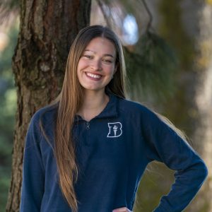 Female student posing in a Bushnell sweater on campus