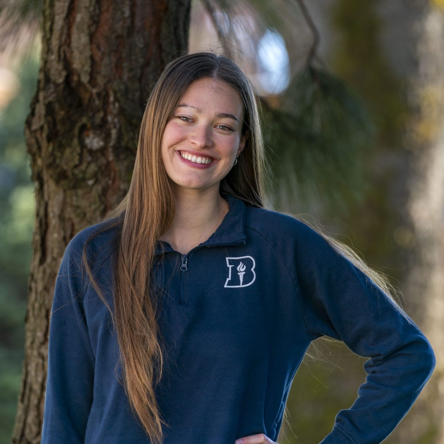 Female student posing in a Bushnell sweater on campus