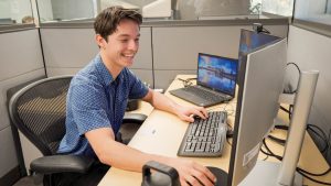 Finance student working at a computer workstation in a professional office environment