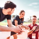 Athletes receive instruction from a fitness coach while on a track