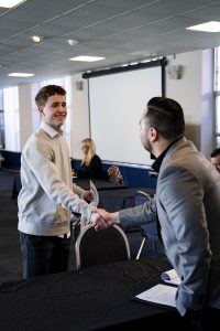 Student shaking hands with a business professional for job interview practice