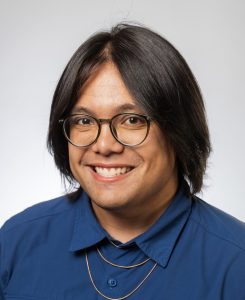 Professional headshot of a male student in a blue shirt with glasses
