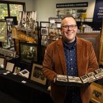 History professor presenting archival photographs and historical artifacts during a university history exhibit