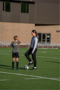 Soccer coach instructs middle school soccer player