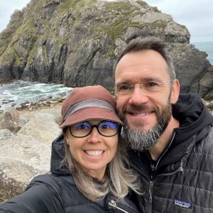 A married couple smile for the camera while at an Oregon coast beach