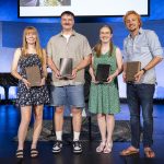 Christian ministry students smile together while holding their bibles