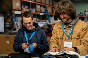 Students organizing clothing donations as volunteers at the Eugene Mission