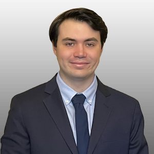 Professional headshot of a student in a blue suit with white backdrop