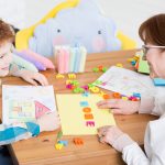 School counselor helps a young student sort out their thoughts through activities like drawing.