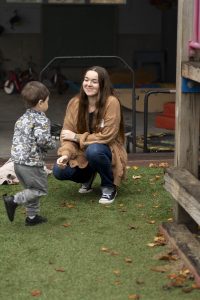Student intern playing with a child at a daycare playground