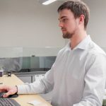 A young student intern focusses on their computer at their finance company internship
