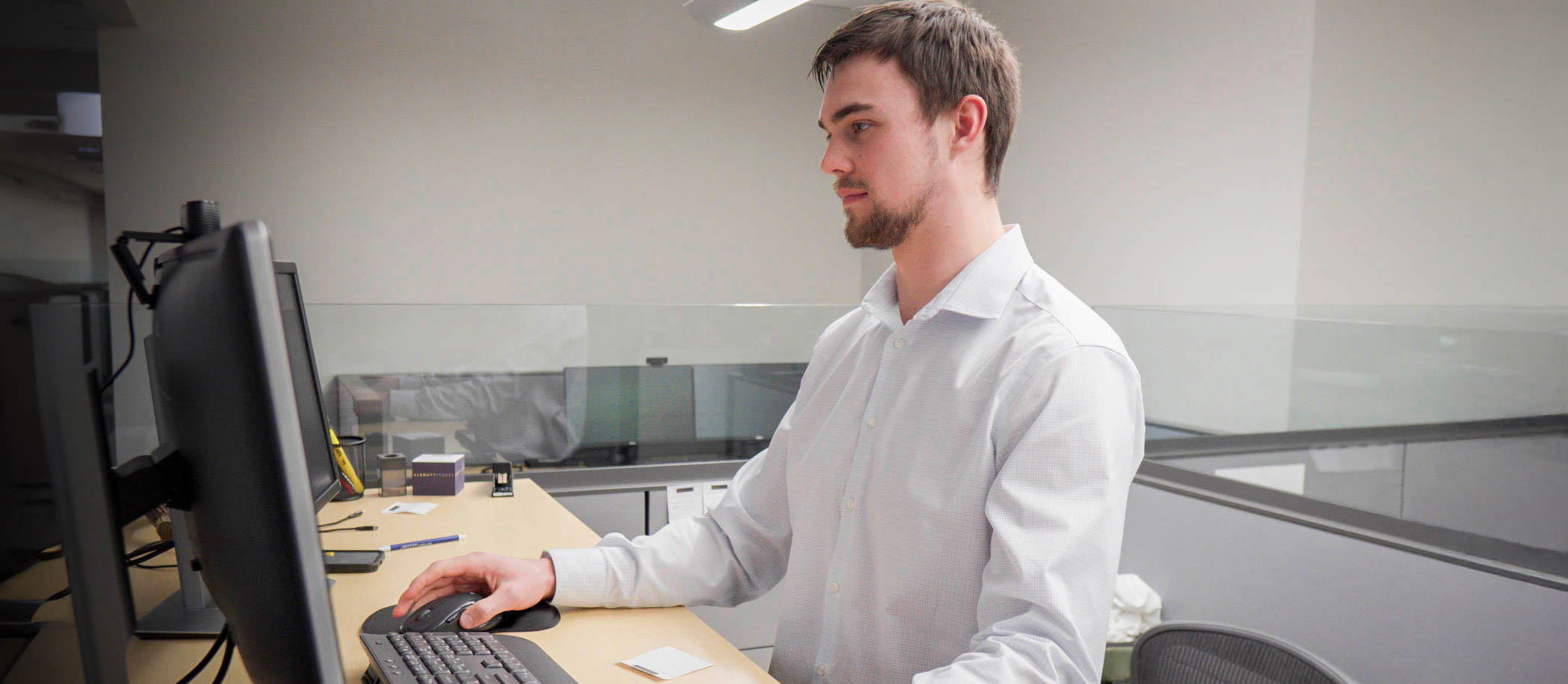 A young student intern focusses on their computer at their finance company internship