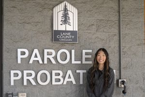 Student poses in front of Lane County Oregon Parole Probation office for internship