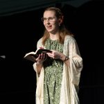 Young female student preaches on stage while holding a bible