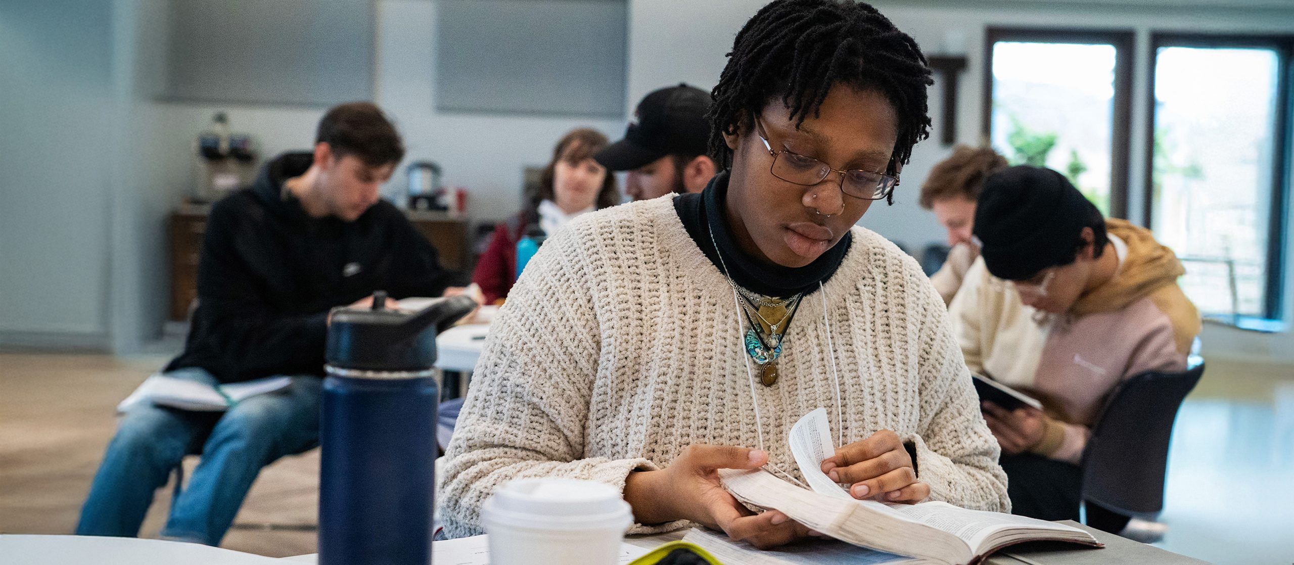 Bible and Theology student reads their bible during a class retreat