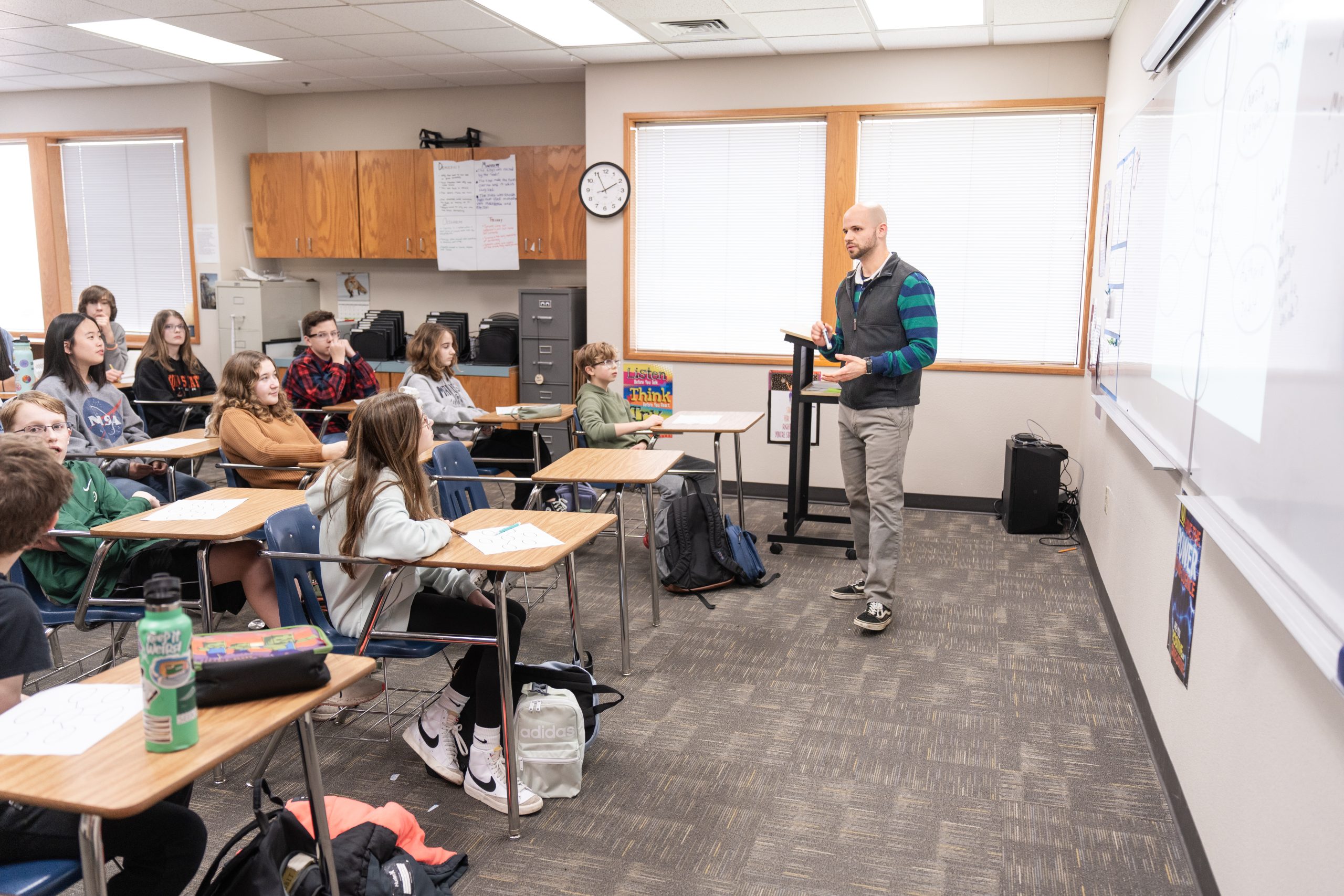 Middle school teacher instructing a full classroom