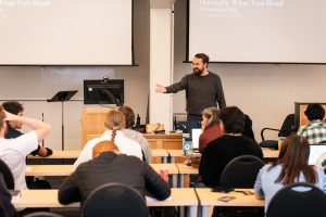 Male theology professor calls on a student to answer a question during class