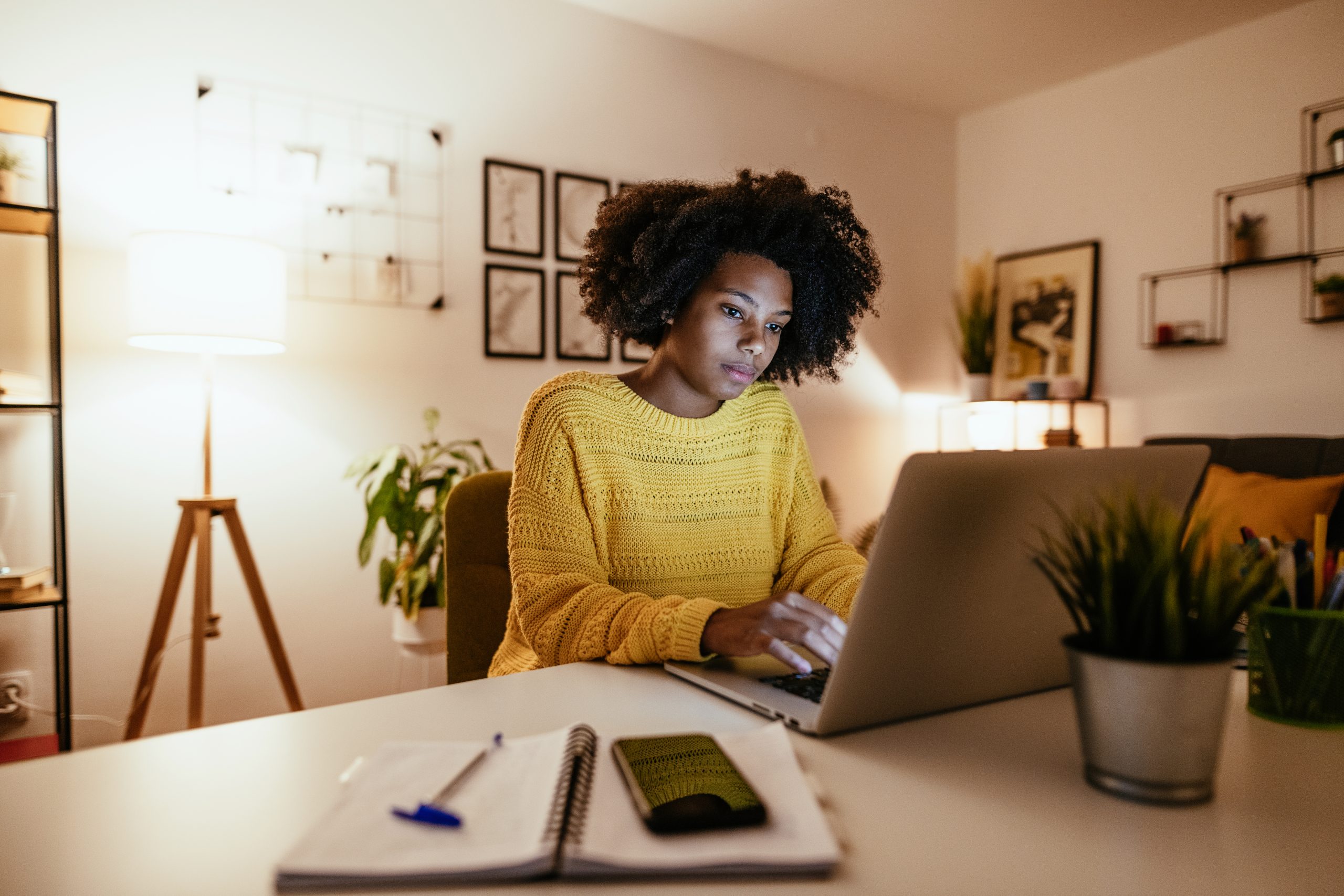 A young woman typing on her laptop in her personal home office