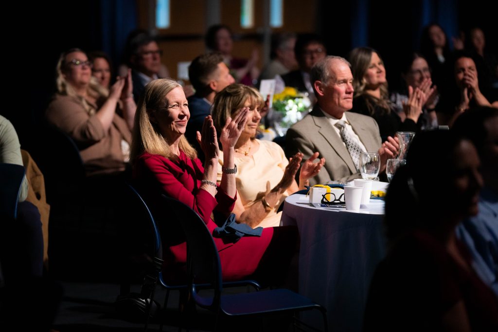 A large crowd of friends and guests of Bushnell University applaud an award recipient during Evening of Tribute.