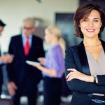 Business professional standing in an office environment representing leadership and career advancement.