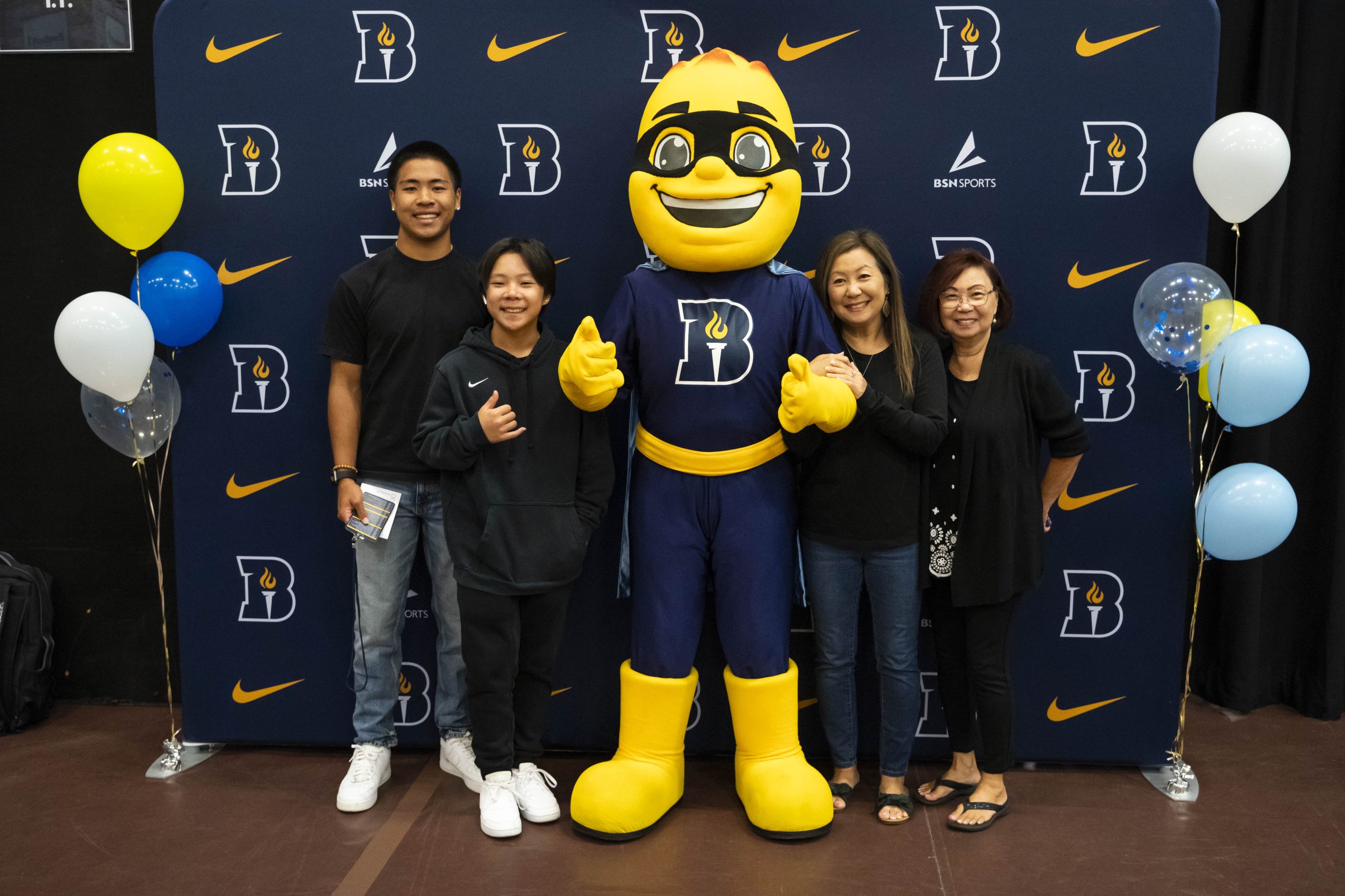 A family poses with Iggy the Beacon during a Bushnell University orientation event.