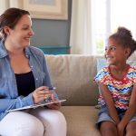 School counselor meeting one-on-one with an elementary student in a supportive counseling session.