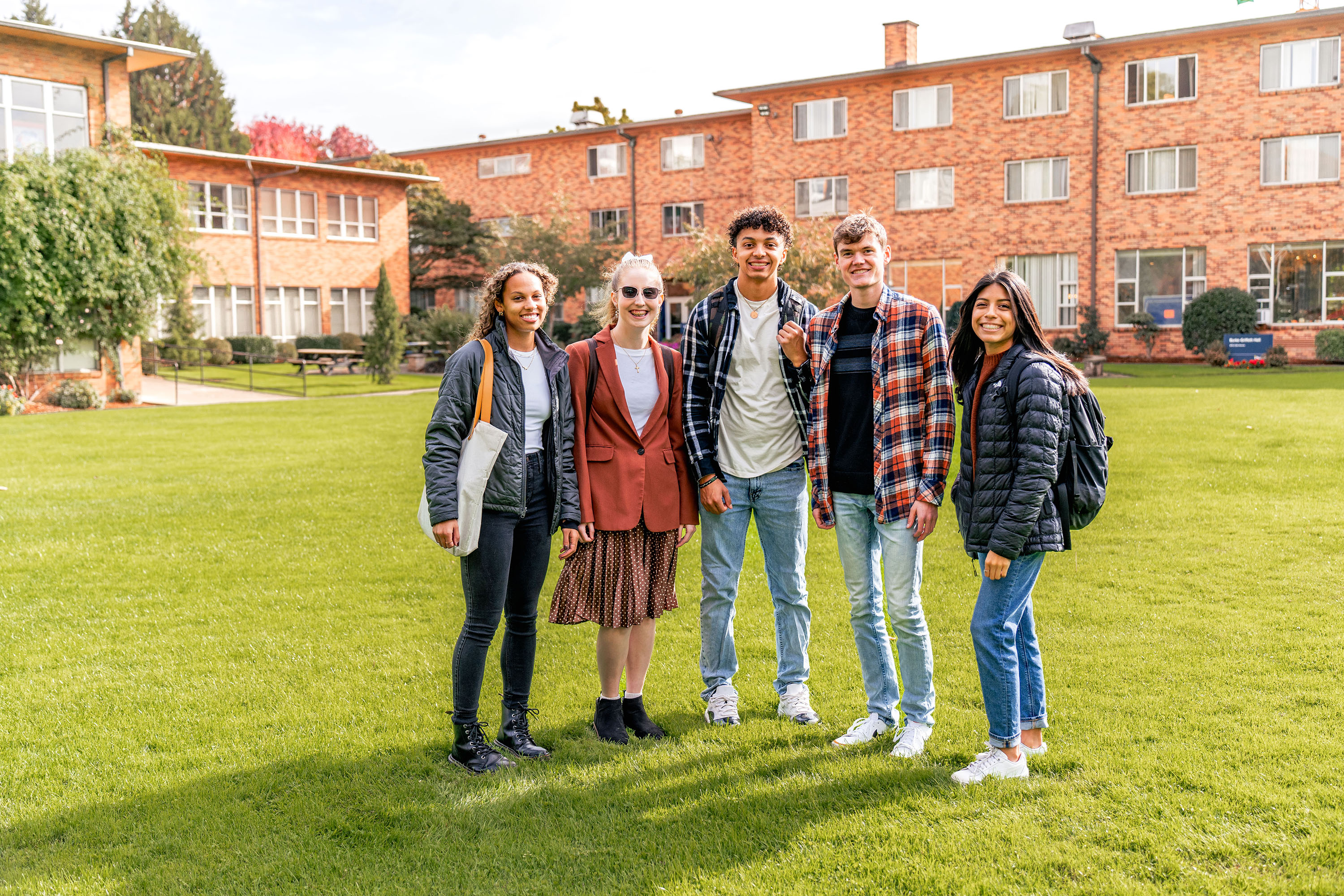 A group of students that have benefited from the Beacon Fund smiling in the campus quad.