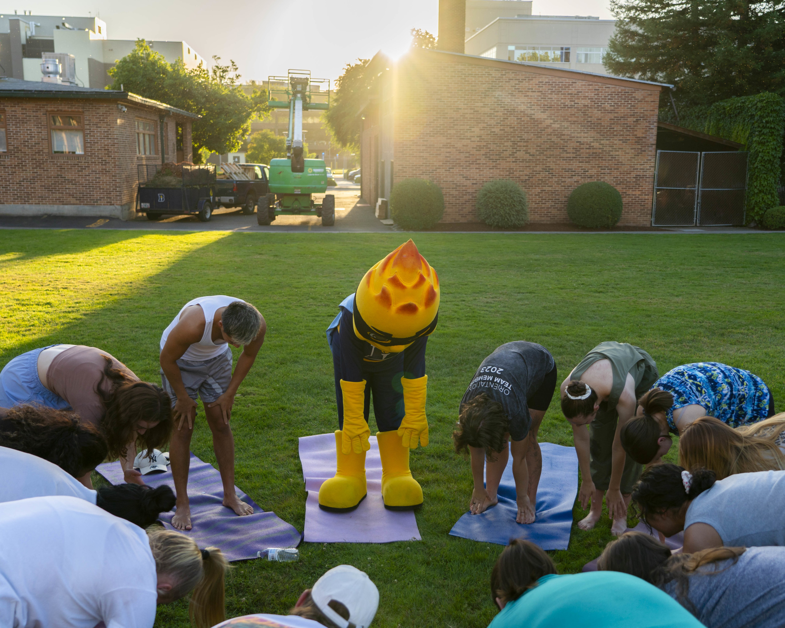 Bushnell University's Beacon mascot joins students during an outdoor yoga event.
